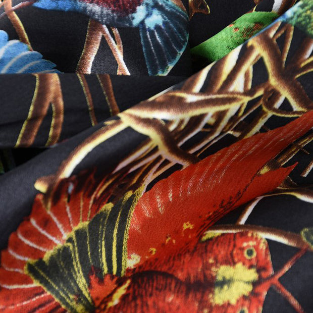 Close-up of Belmore Boutique black and gold hummingbird print silk scarf.