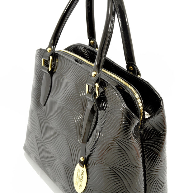 Side of Giordano Mary black patent leather handbag. 